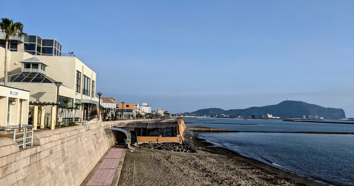 海沿いの遊歩道と建物が並ぶ穏やかな海岸風景