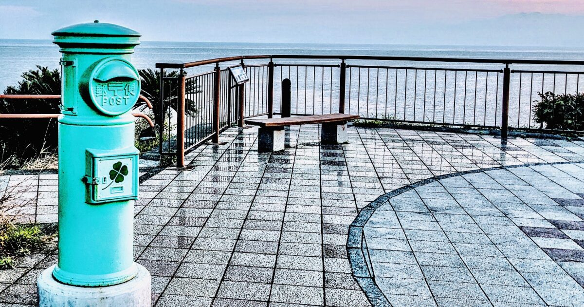 海を望む展望デッキに設置されたレトロなポストとベンチ