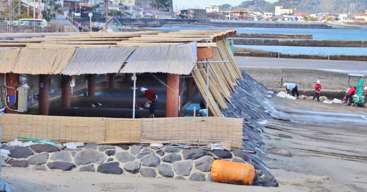 砂むし温泉施設で砂かけ作業を行うスタッフと利用者の様子