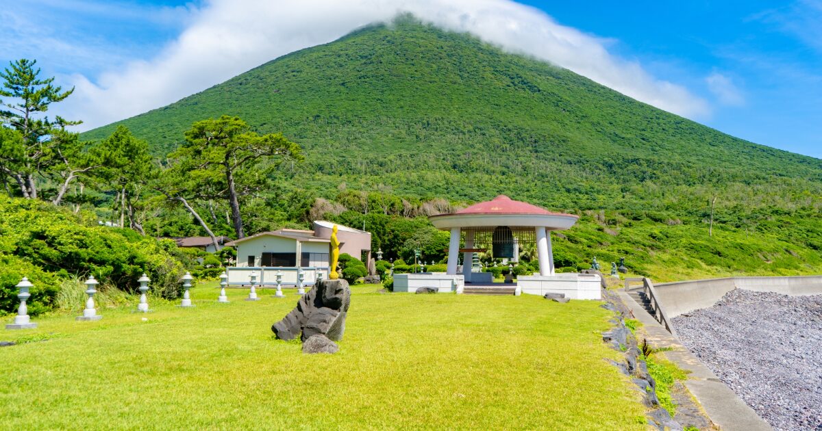 開聞岳を背景にした庭園と記念碑のある公園風景
