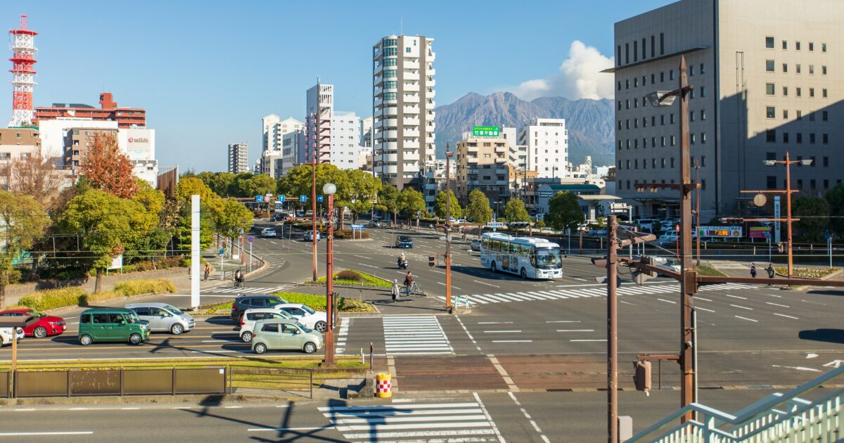 鹿児島市中心部と桜島を望む交差点の街並み