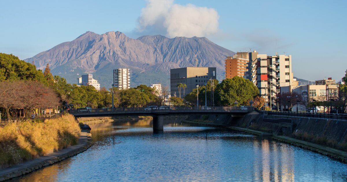 桜島と川に架かる橋と鹿児島市街の風景