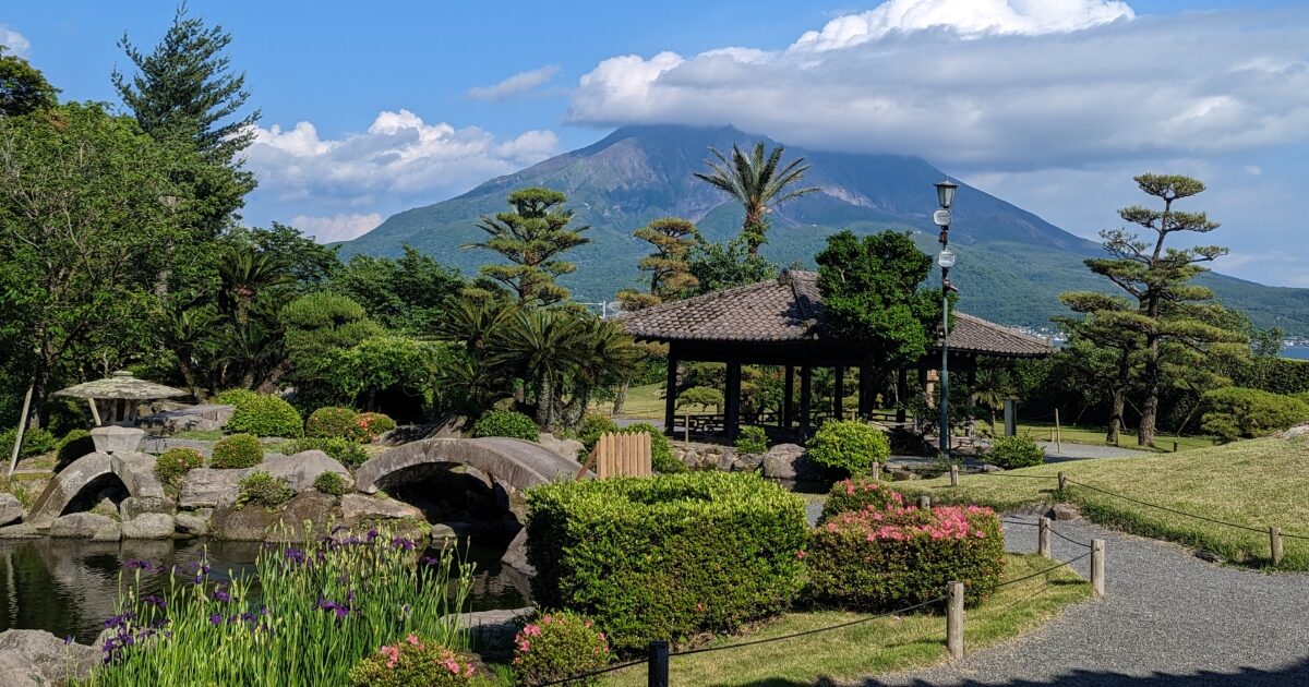 桜島を背景にした日本庭園と東屋の景観