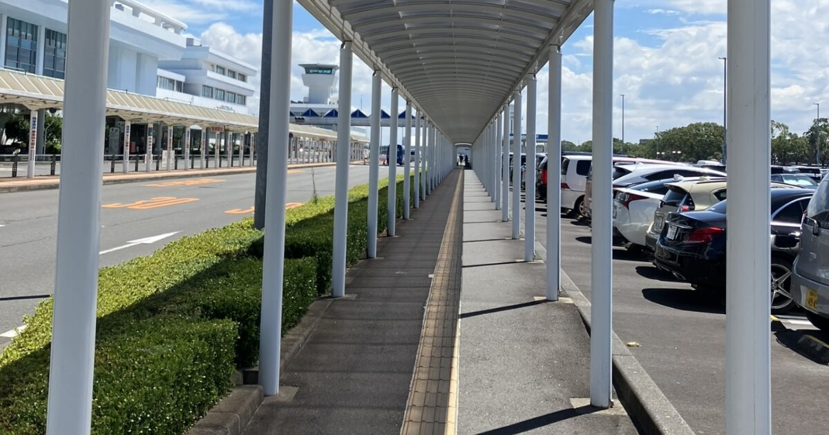 空港の屋根付き歩道と駐車場が並ぶアクセス通路