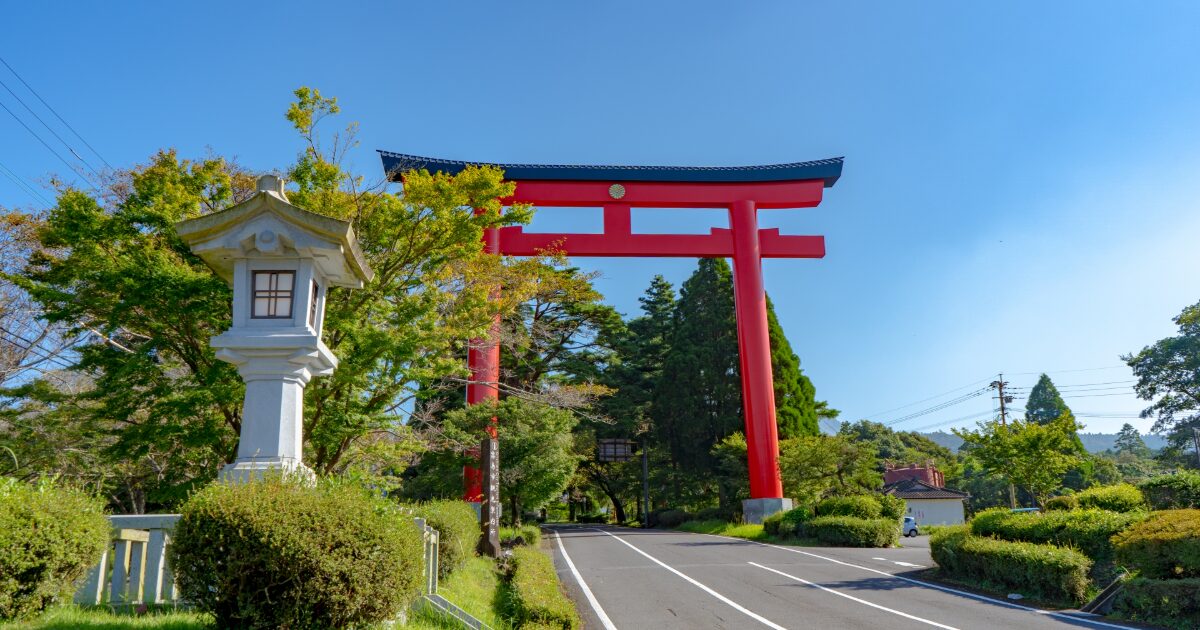 朱色の鳥居と緑に囲まれた神社の参道風景