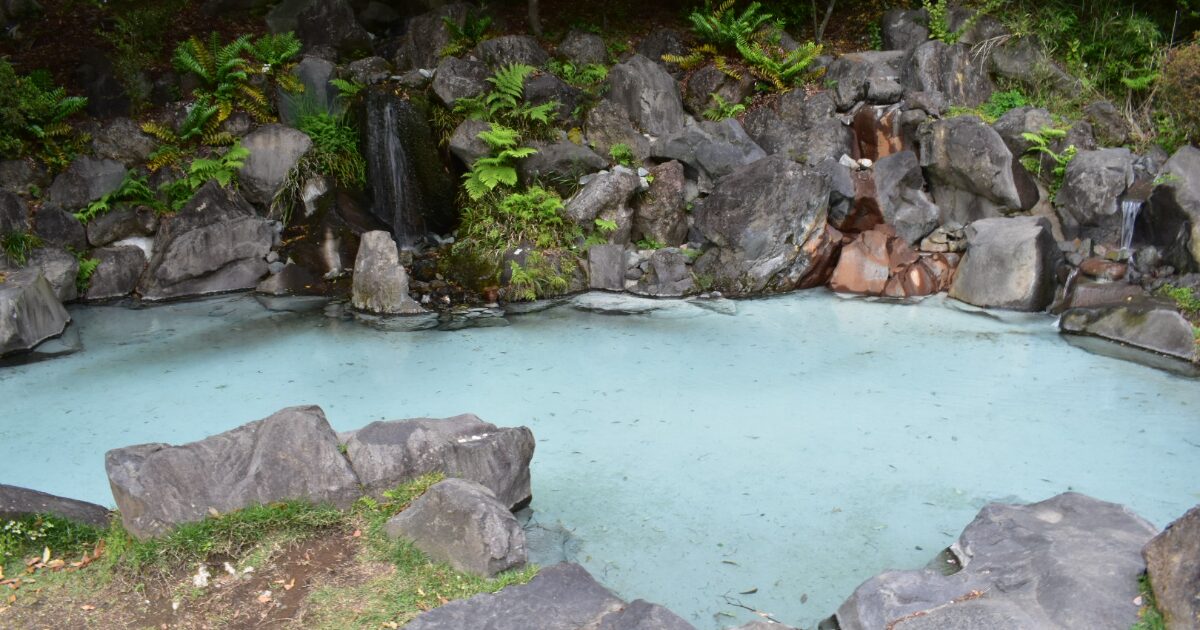 岩に囲まれた天然温泉と青白い湯の露天風呂