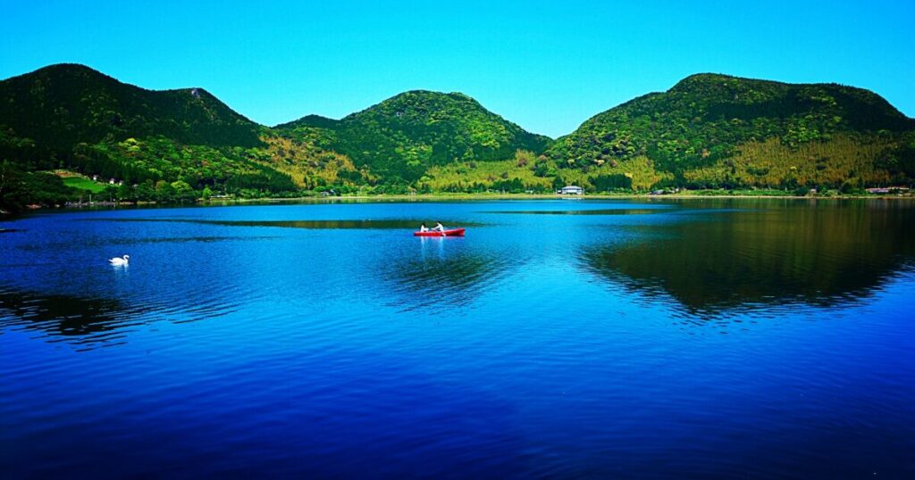 緑豊かな山々に囲まれた穏やかで青い藺牟田池の湖畔