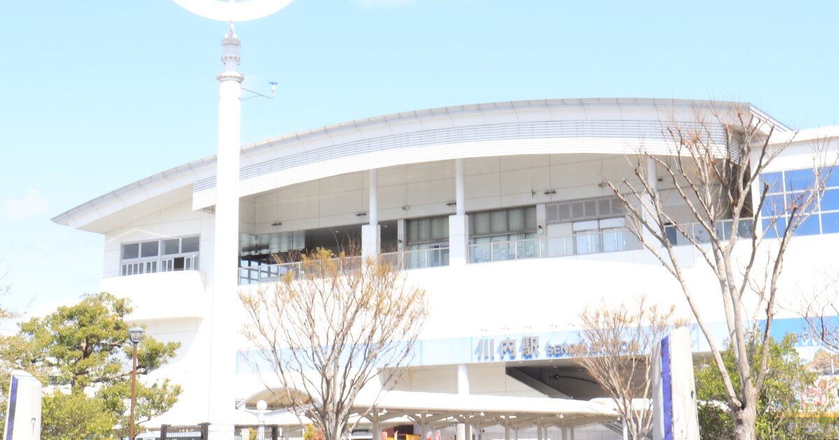 青空の下に佇む白を基調とした近代的な外観の川内駅