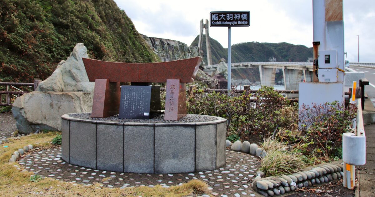 甑大明神橋の銘板と石造りの鳥居のモニュメント